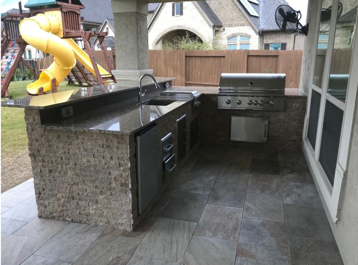 A kitchen with a grill and a slide in the background
