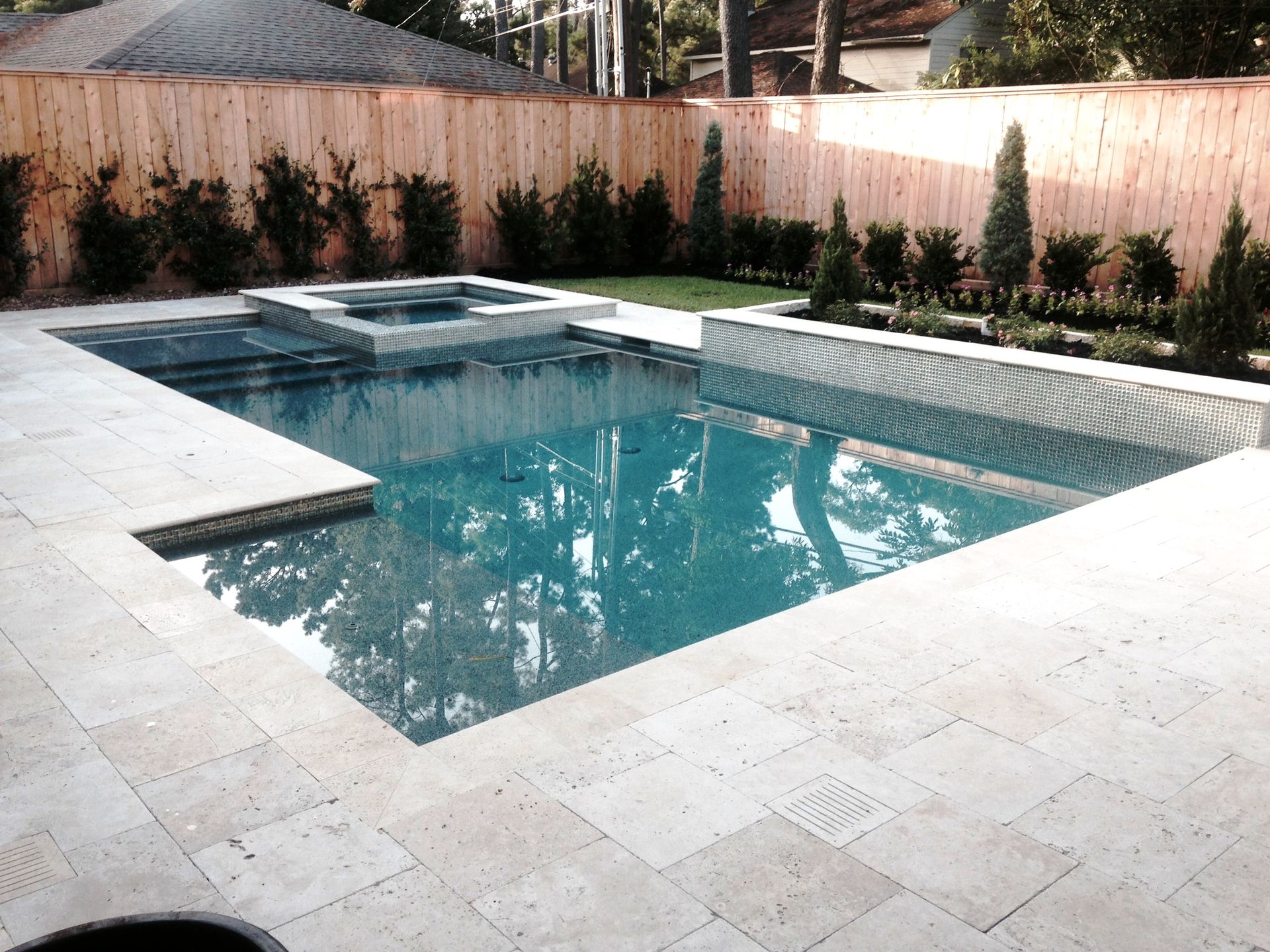 A large swimming pool with a wooden fence surrounding it