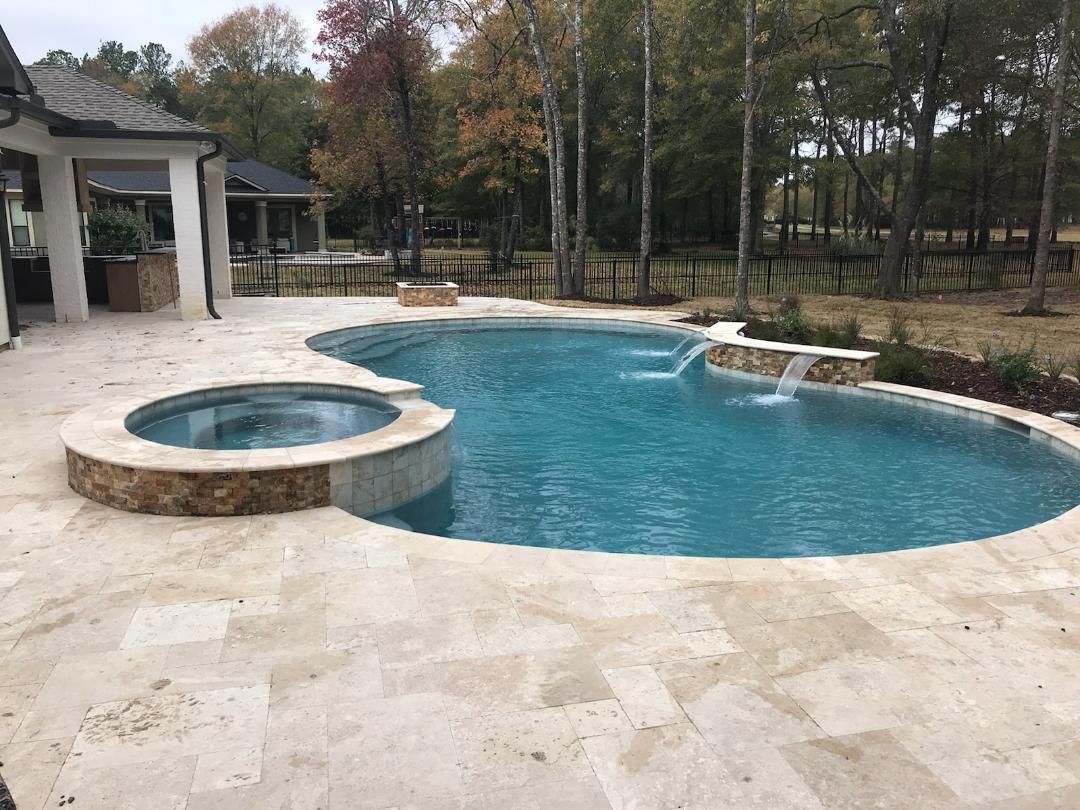 A large swimming pool with a hot tub in the backyard of a house.
