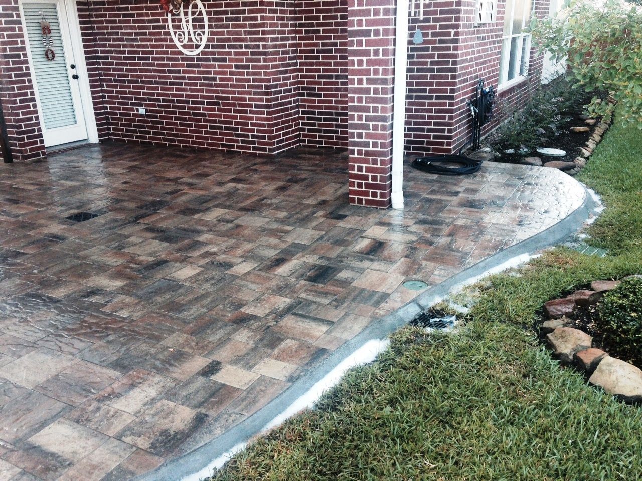 A brick house with a patio in front of it.