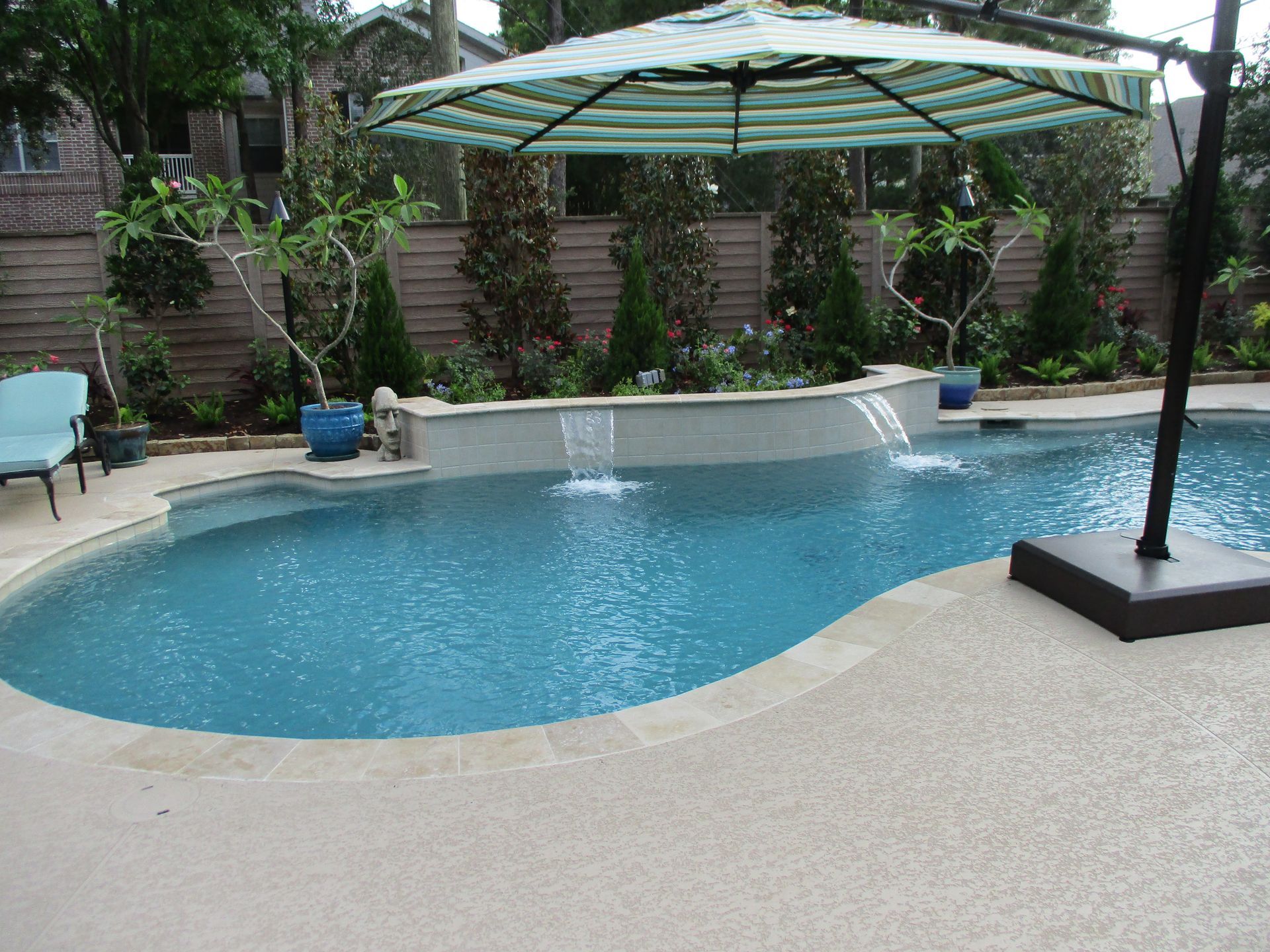 A large swimming pool with a striped umbrella over it