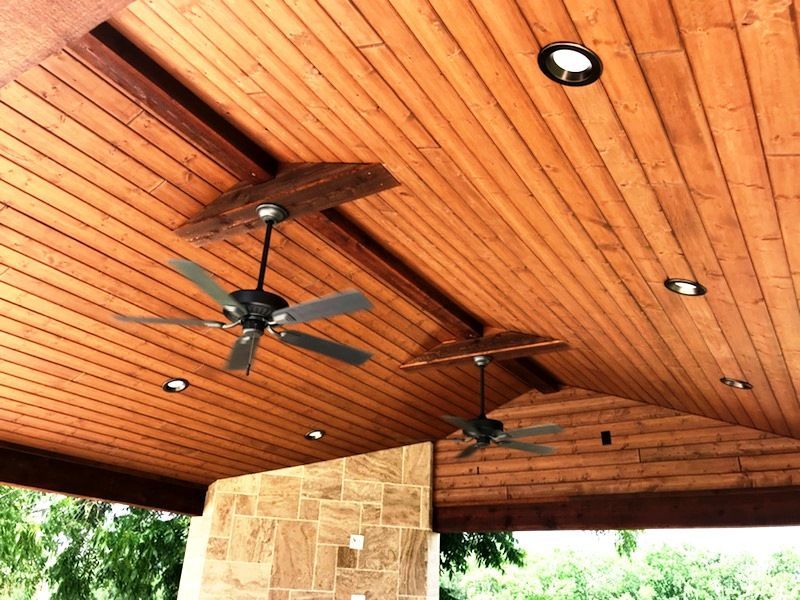 Three ceiling fans are hanging from a wooden ceiling
