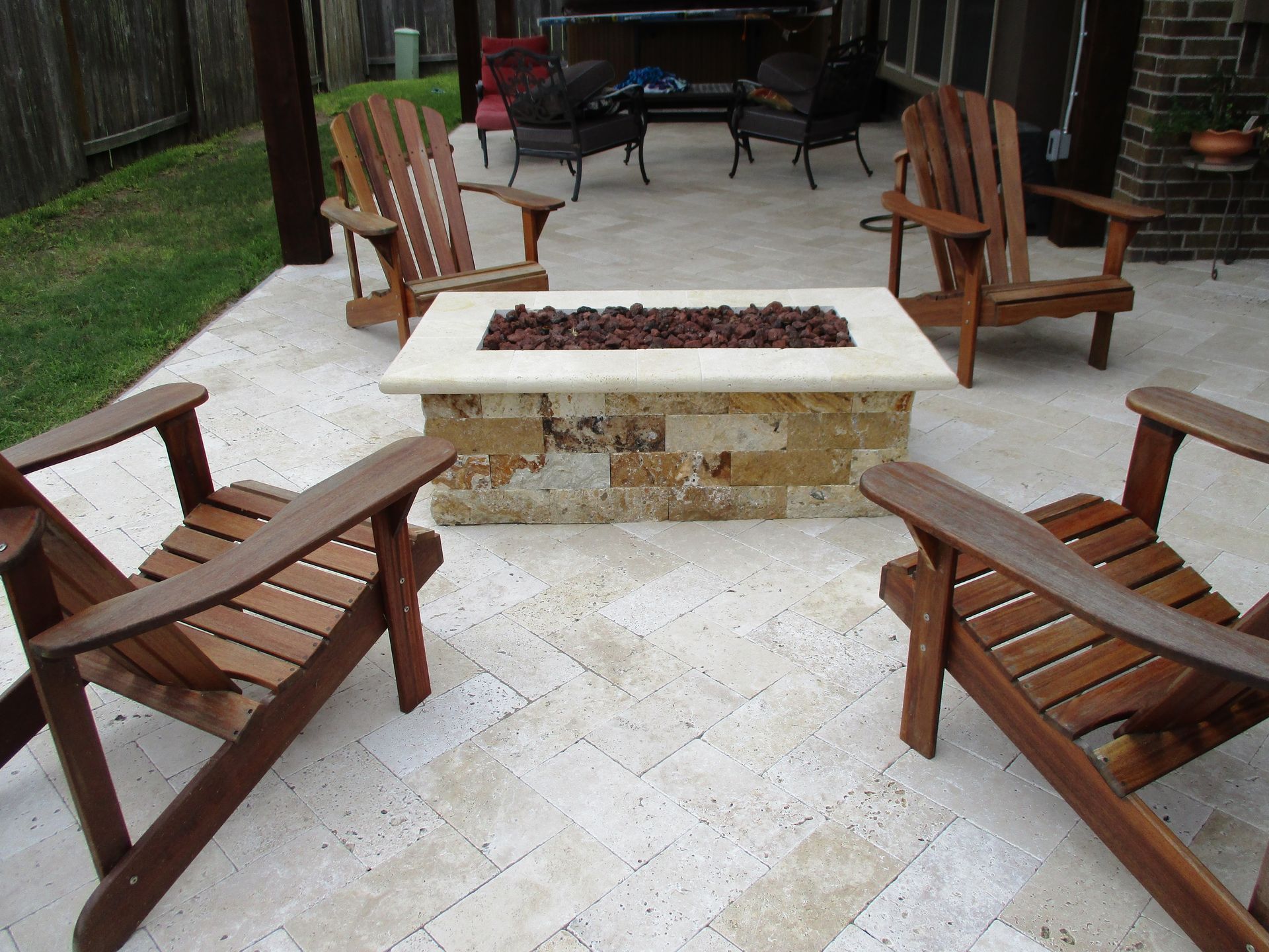 A fire pit surrounded by wooden chairs on a patio