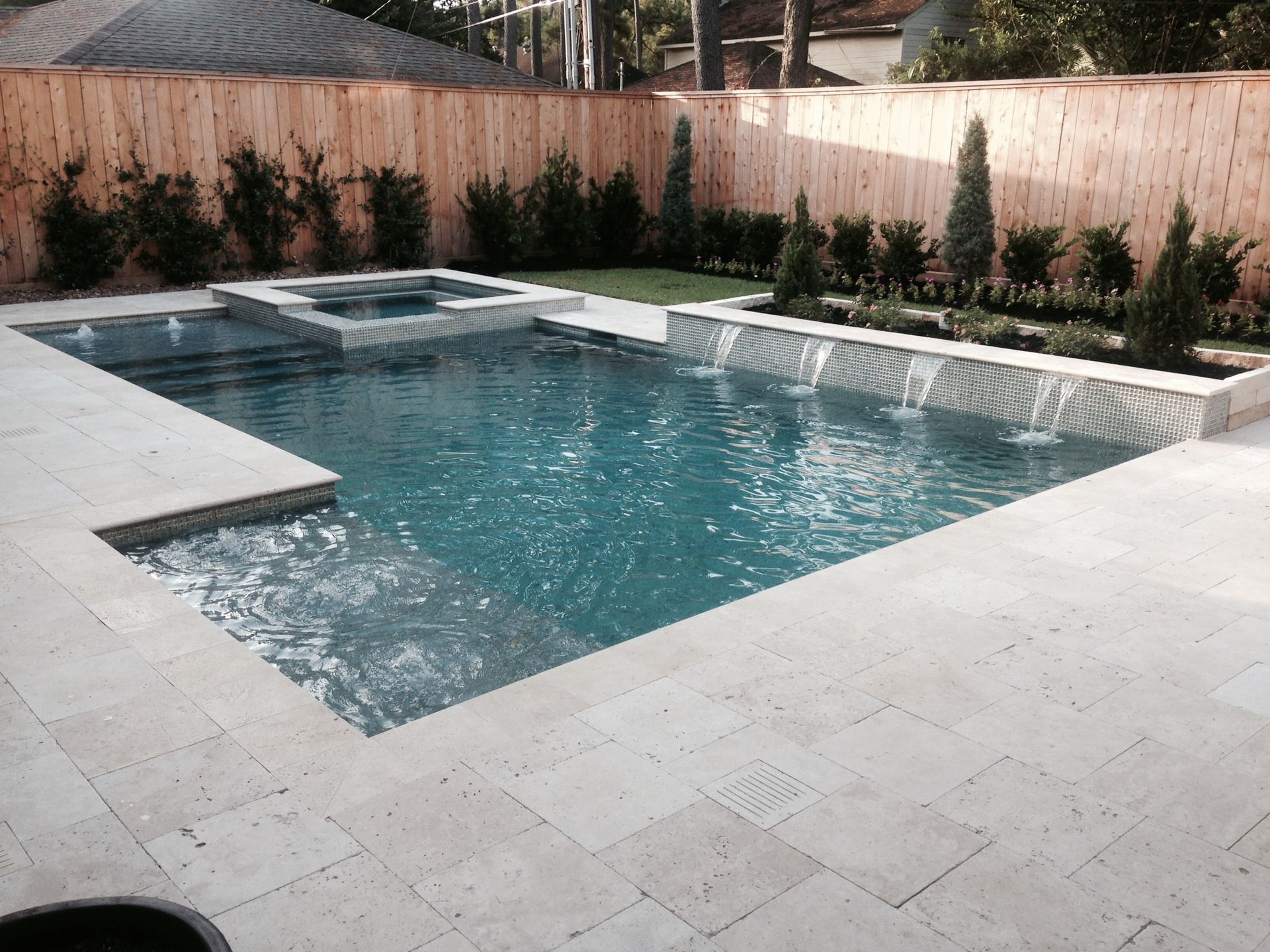 A large swimming pool with a wooden fence surrounding it