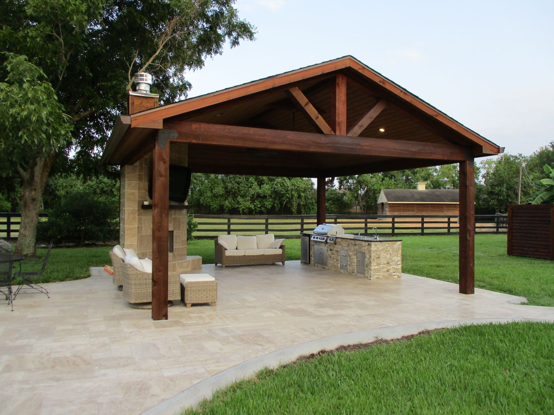 A pavilion with a couch and a grill underneath it