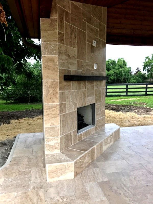 A tiled fireplace with a fence in the background