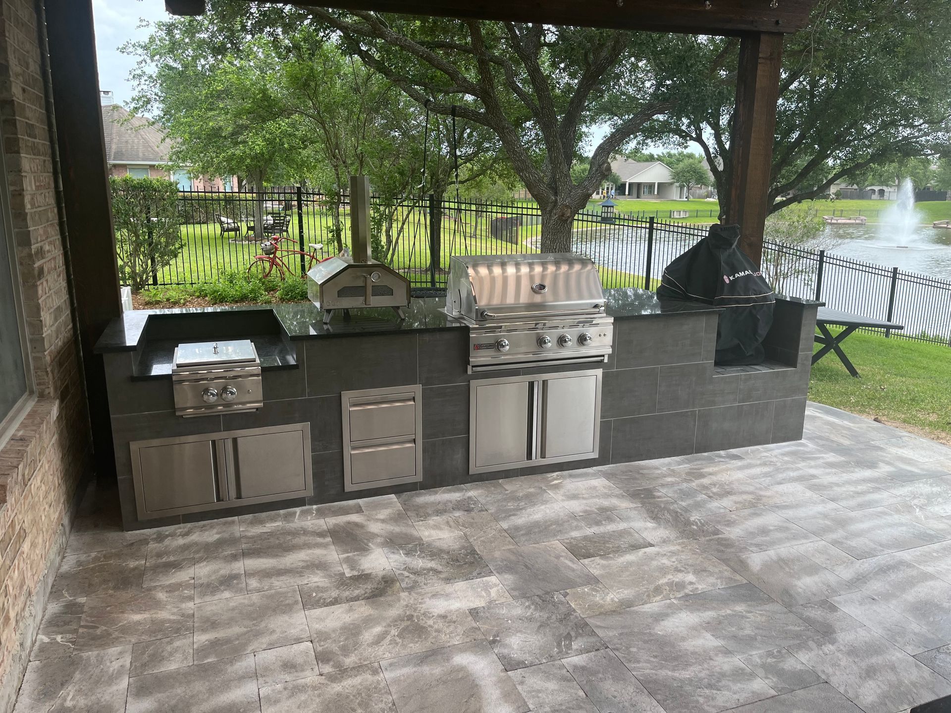 A large outdoor kitchen with stainless steel cabinets and a grill.