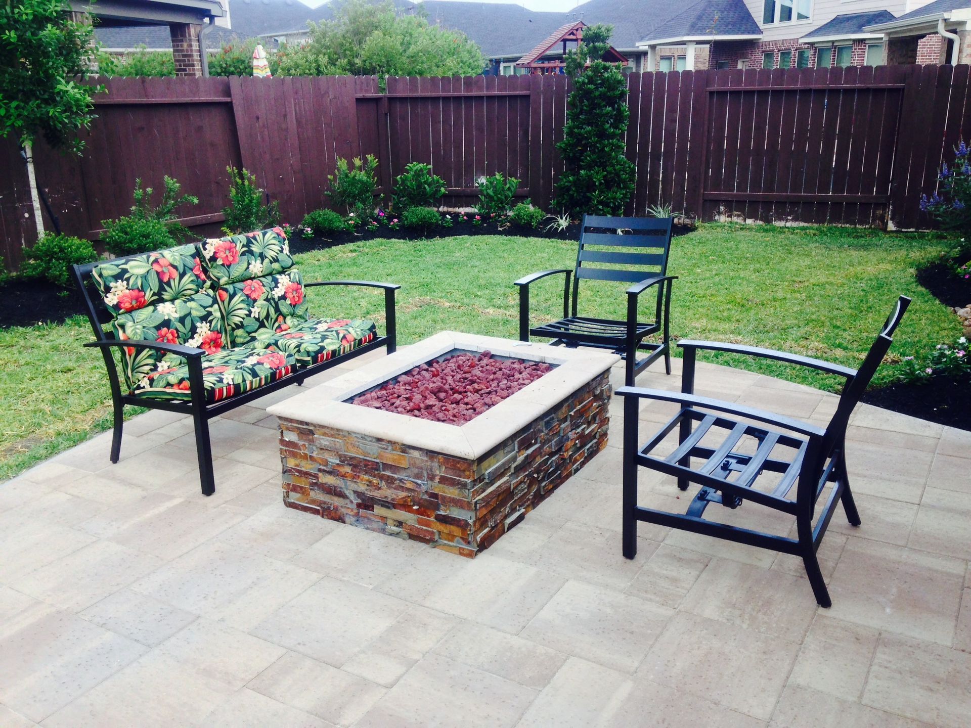 A fire pit is surrounded by chairs and a bench