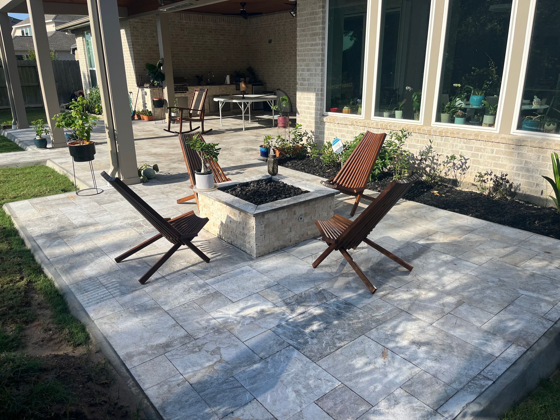 Two chairs are sitting on a patio next to a fire pit.