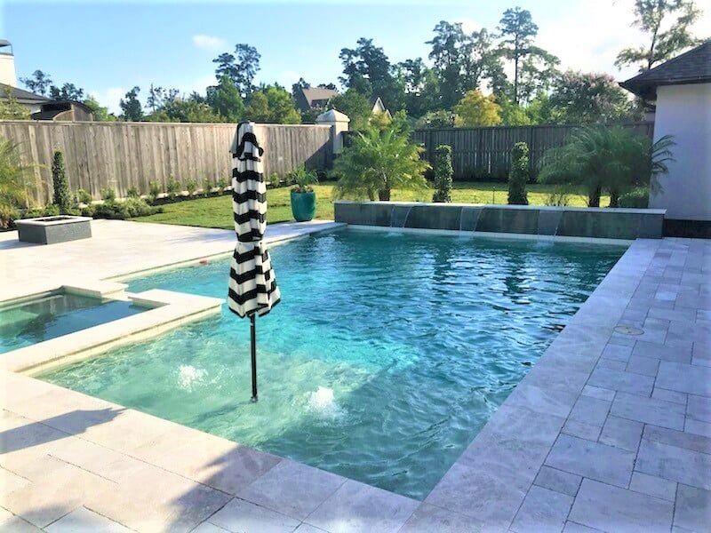 A large swimming pool with a black and white striped umbrella in the middle
