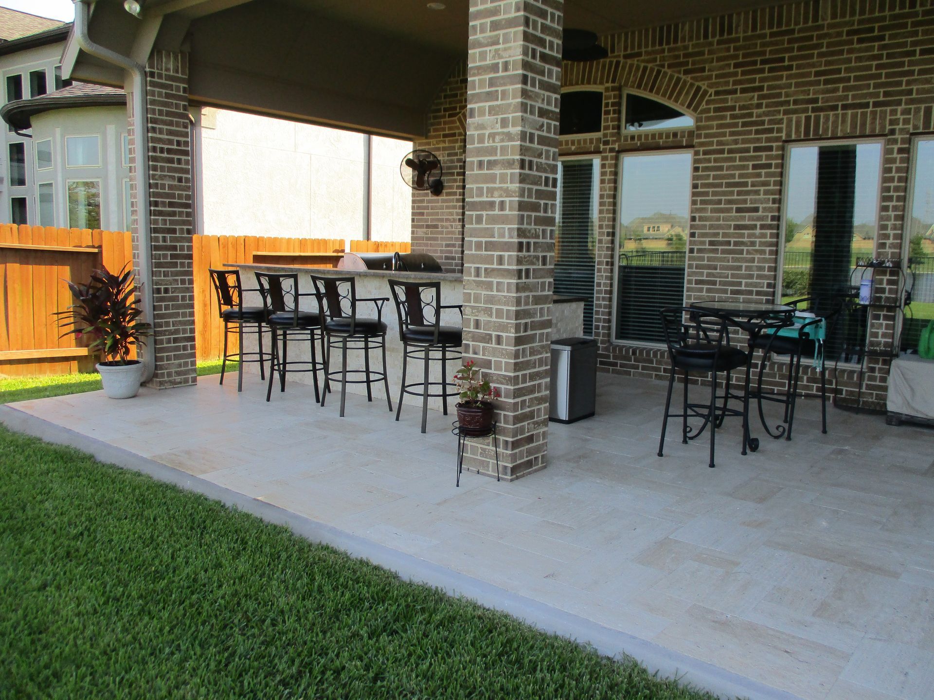 A patio with tables and chairs in front of a brick house.
