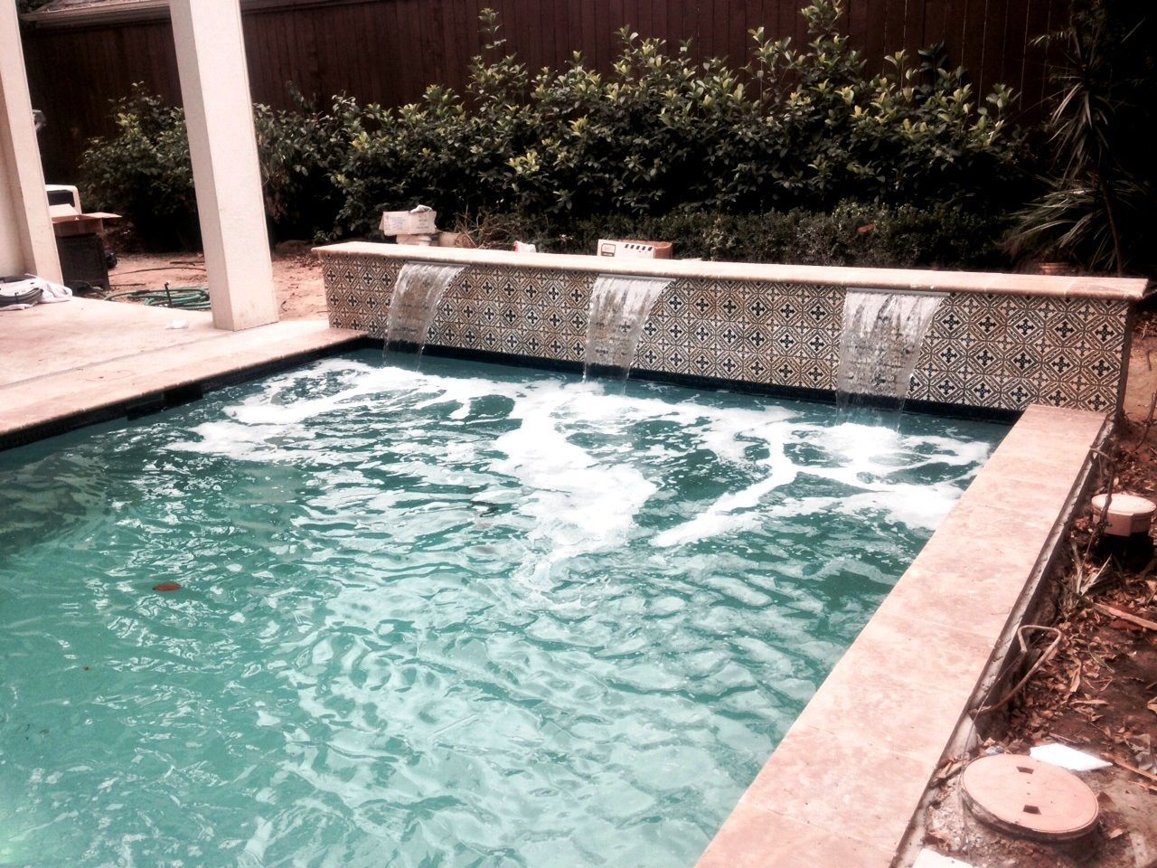 A swimming pool with a waterfall in the middle of it