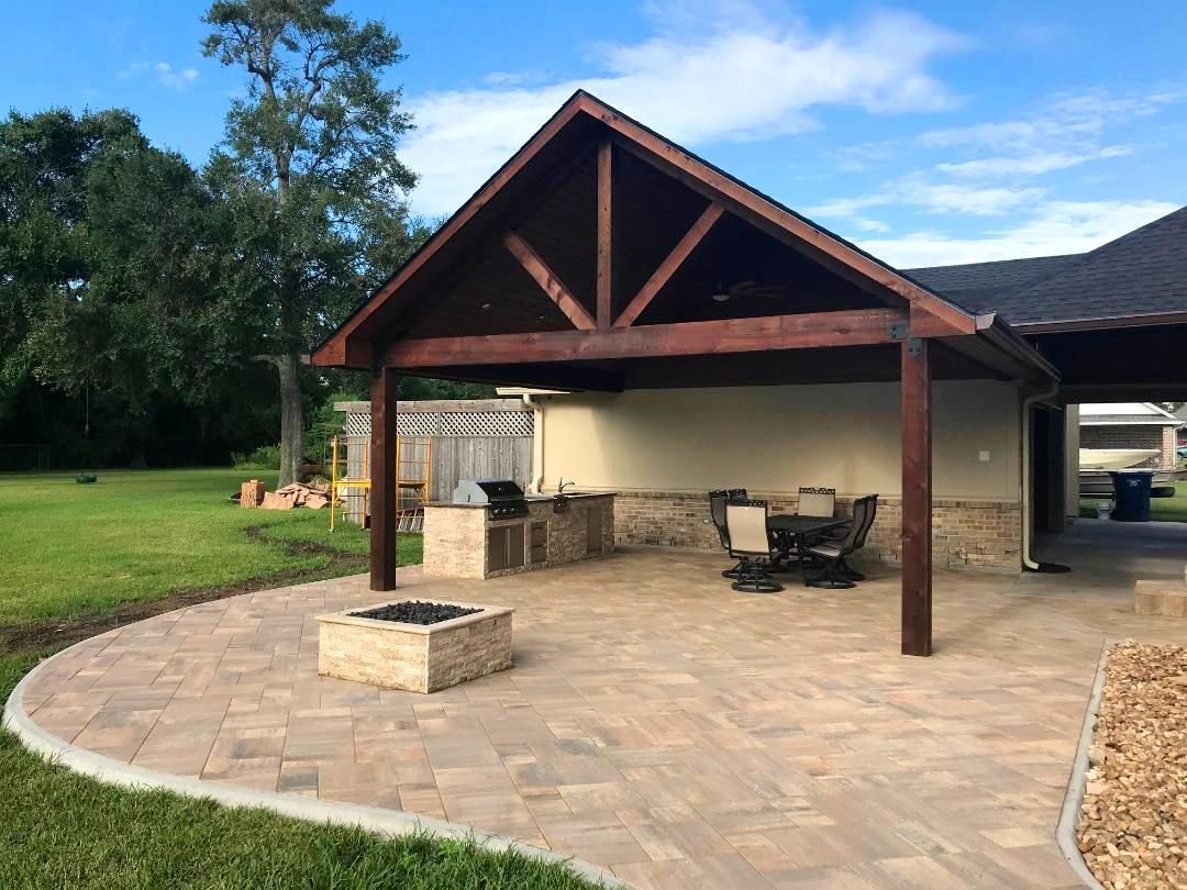 A patio with a fire pit and a pavilion in the backyard.