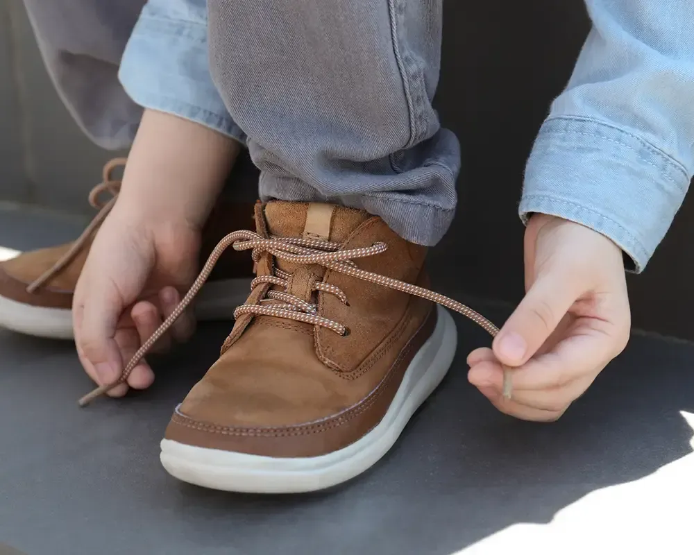 Un primer plano de una persona atándose los zapatos.