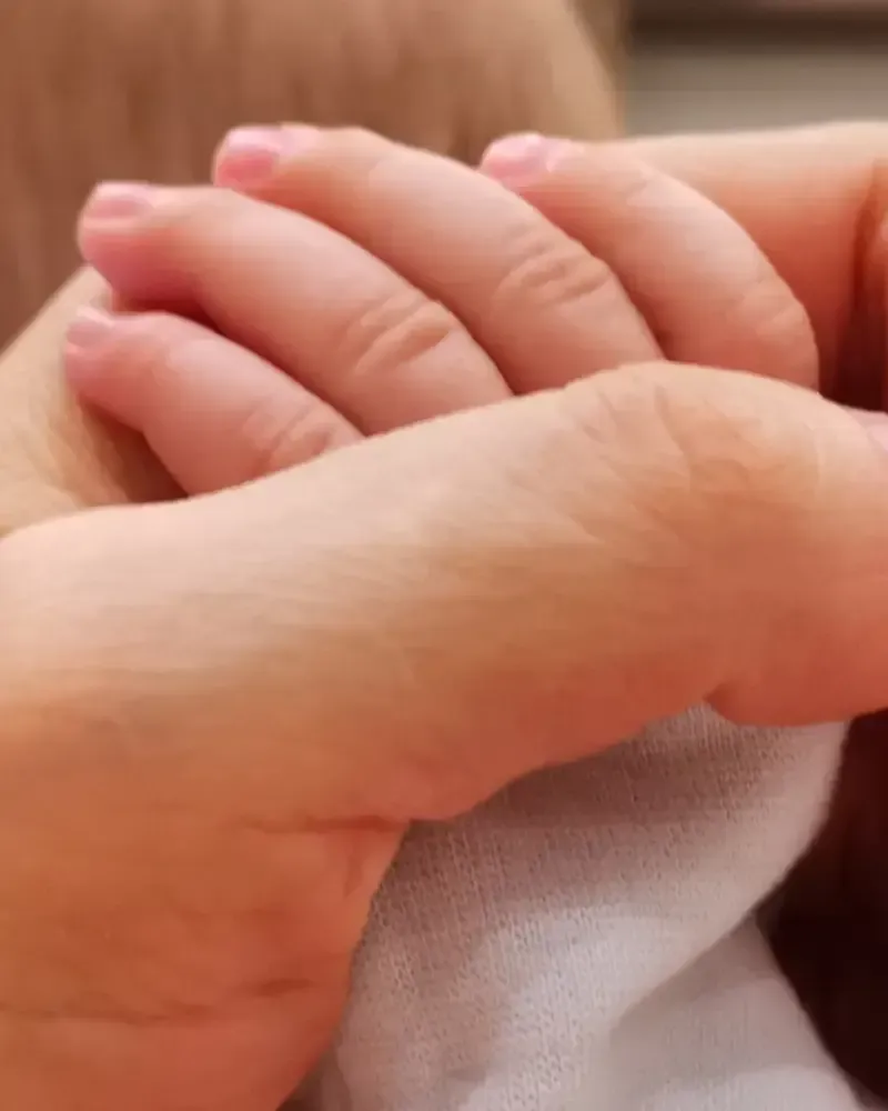 Mano adulta y mano de bebé