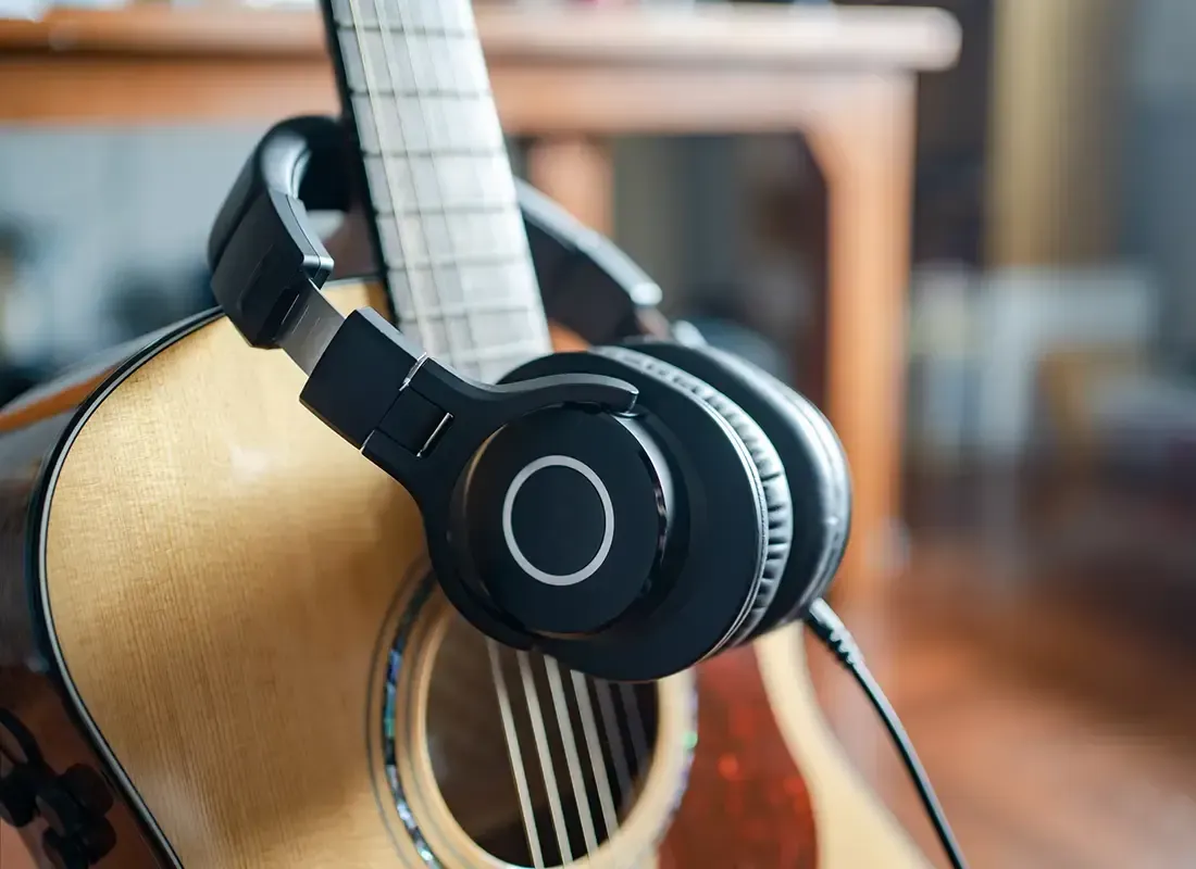 Una guitarra acústica con auriculares conectados.