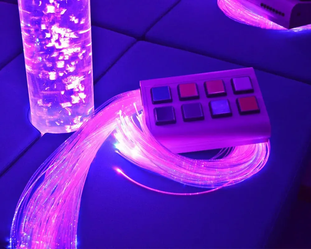 Un control remoto morado se encuentra sobre una mesa junto a una luz morada.