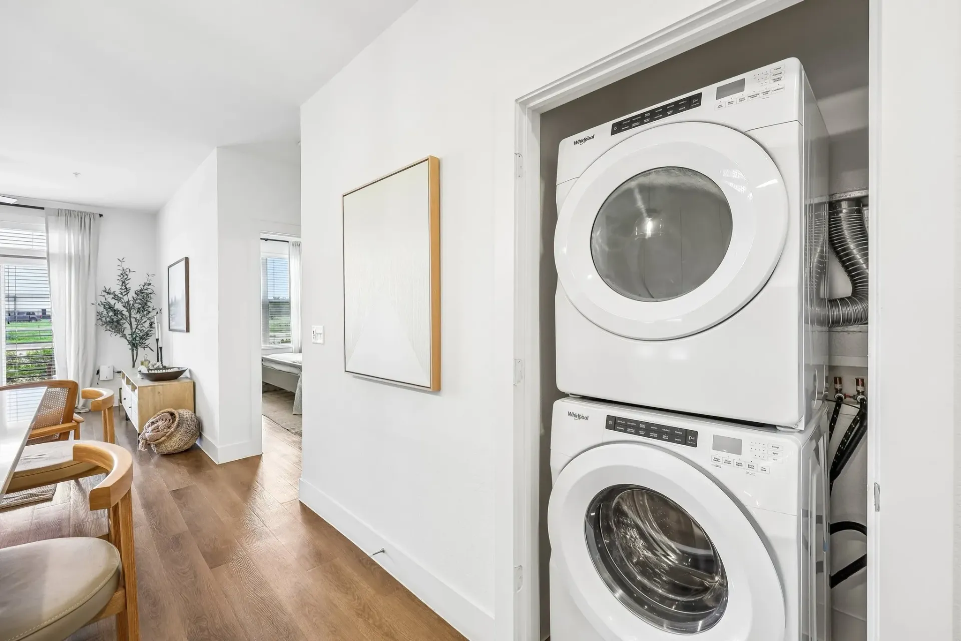 Stacked white Whirlpool washer and dryer in a closet.
