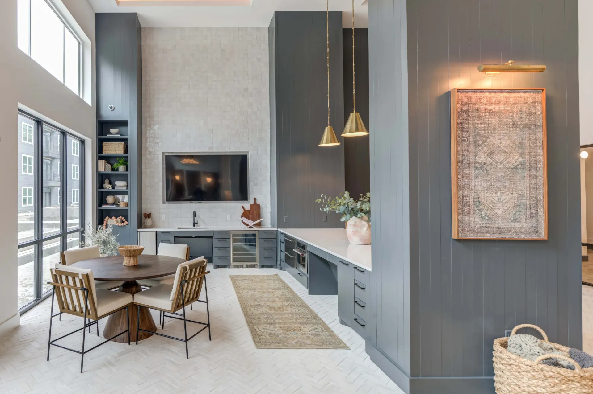 Modern communal lounge area with a large TV, a wet bar, and a dining table.