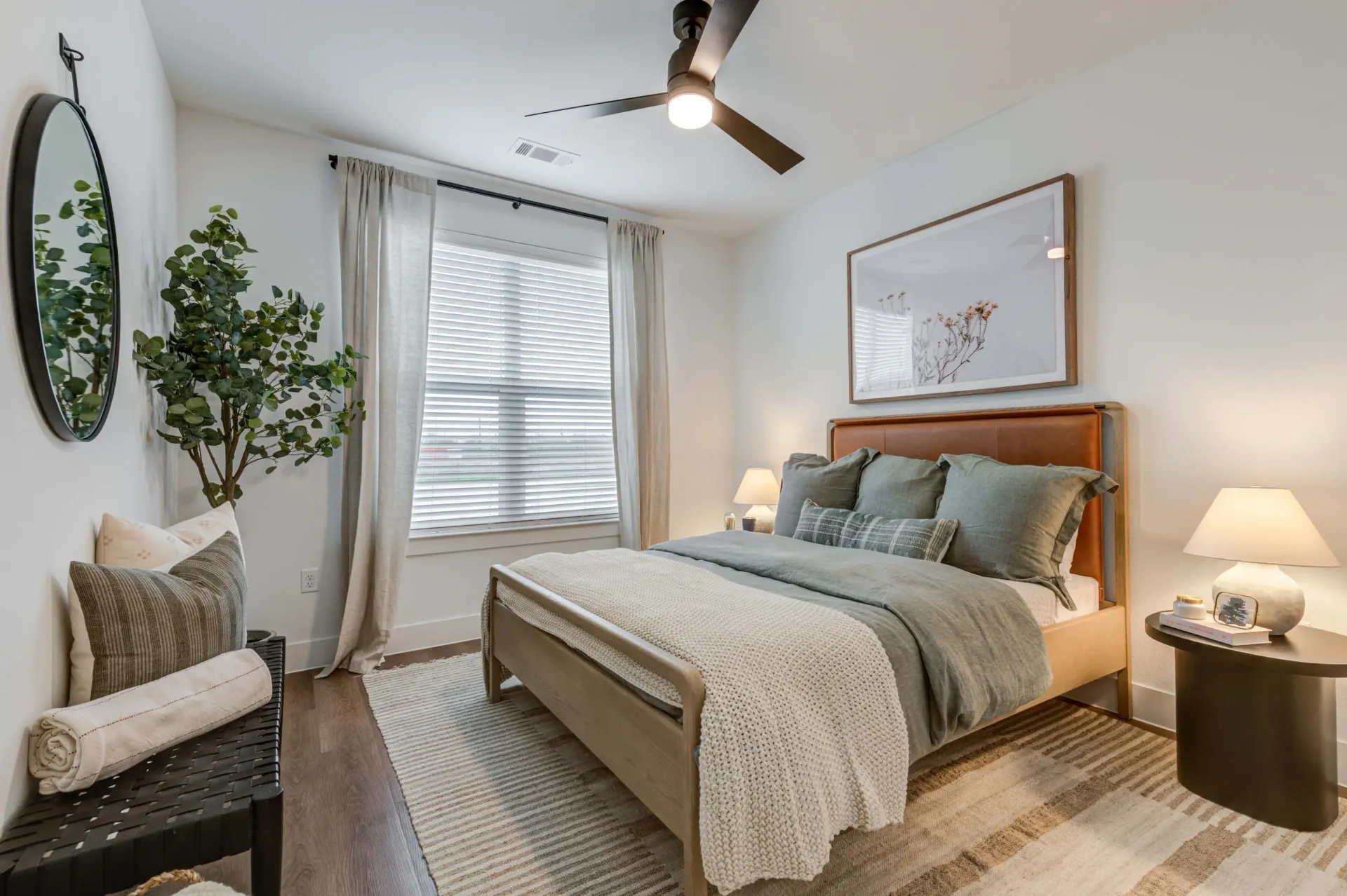Spacious bedroom with a king-size bed, ceiling fan, and large window.