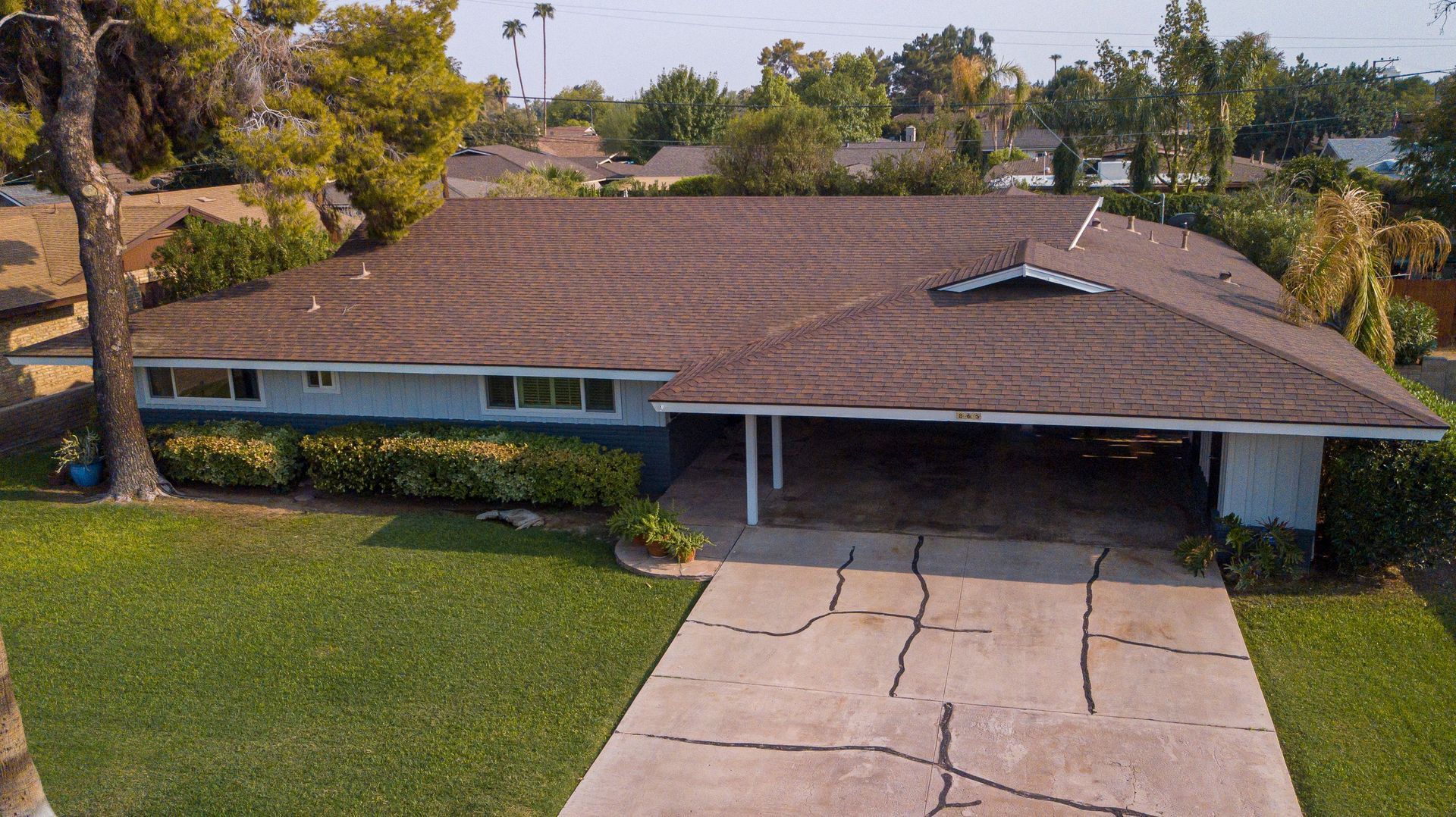 Single-story suburban house with a brown roof, front lawn, and driveway