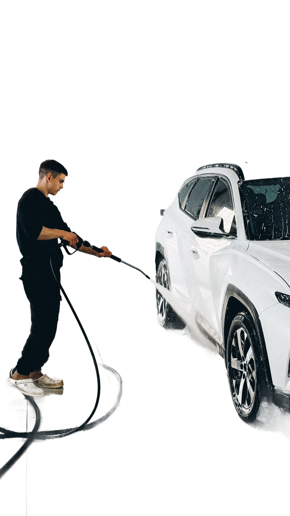 Person washing a white car with a pressure washer in a soapy studio setting