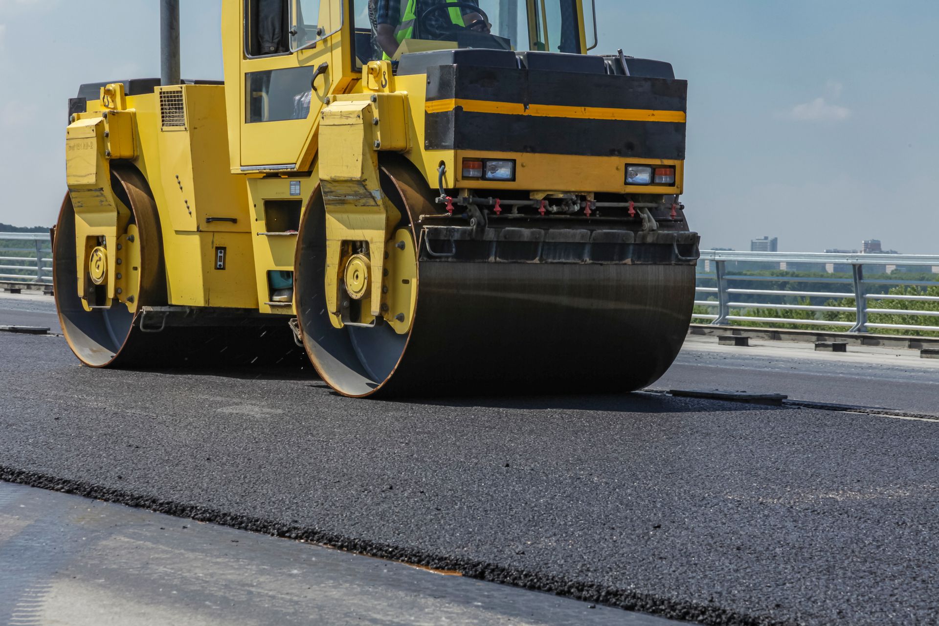 Road worker compacts asphalt on a pothole. Road worker compacts asphalt on a pothole.