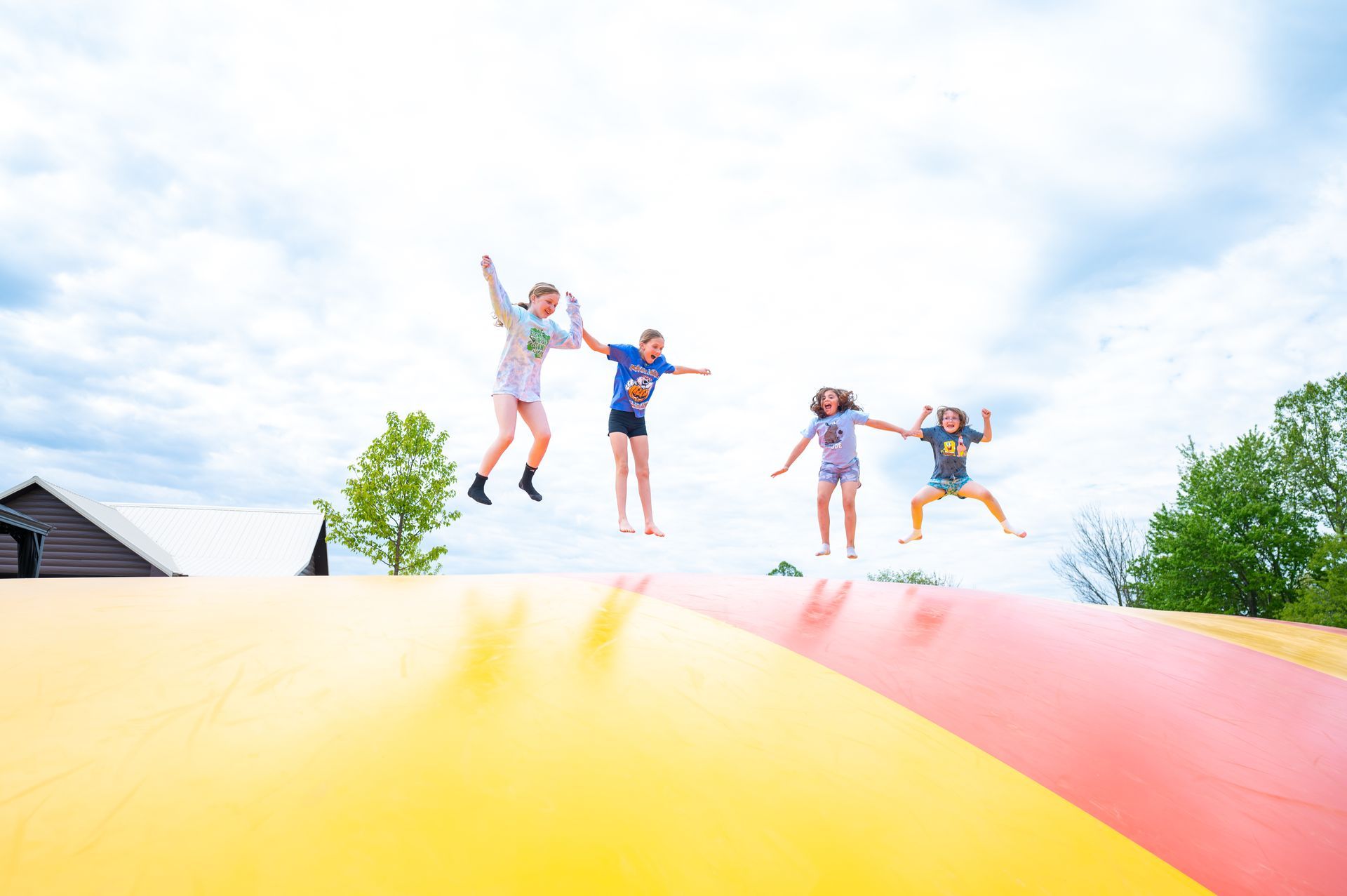 A group of children are jumping on a bouncy pillow.