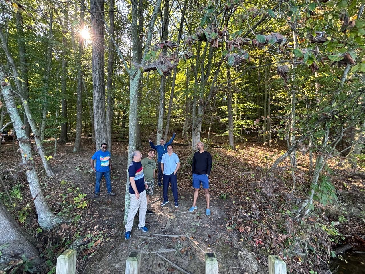 A group of men are standing next to each other in the woods.