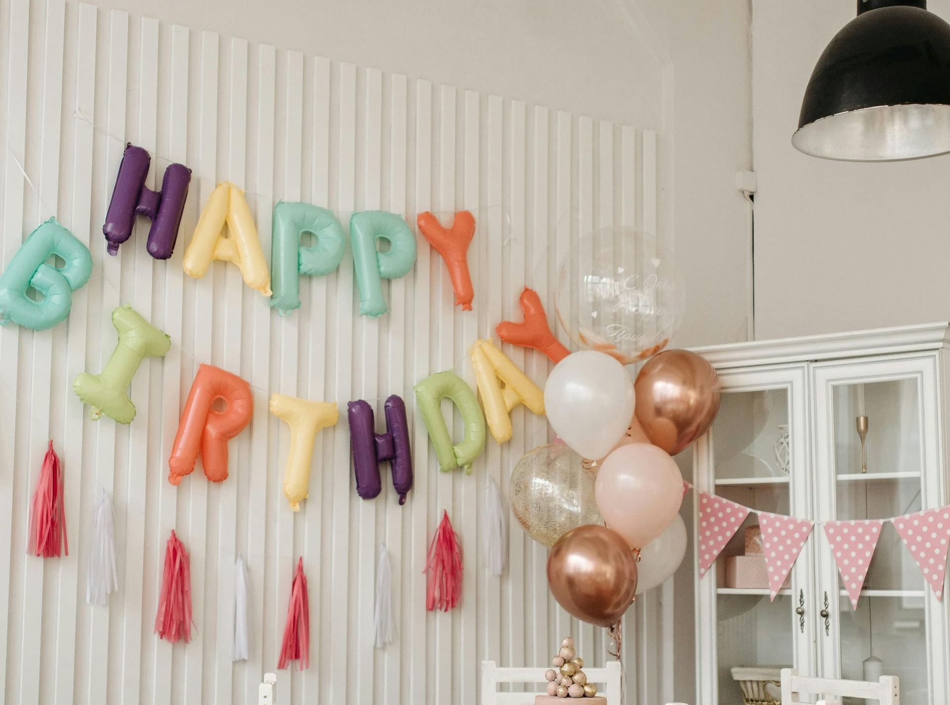 A room decorated with balloons and a sign that says `` happy birthday ''.
