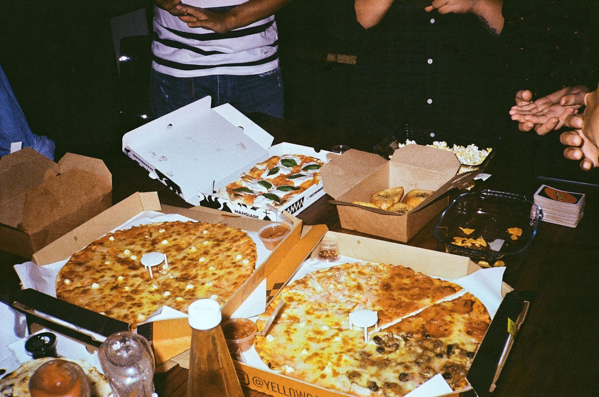 A group of people are sitting around a table eating pizza