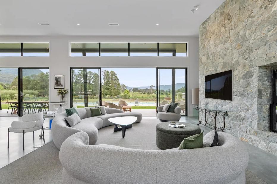 A Living Room With A Curved Couch , Chairs , and A Flat Screen TV — That Painter Guy In South Nowra, NSW