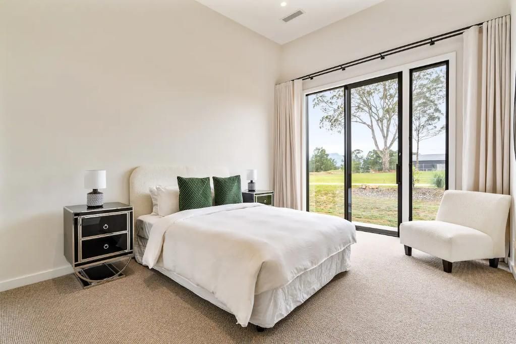 A Bedroom With A Bed , Chair , Nightstand and Sliding Glass Doors — That Painter Guy In South Nowra, NSW