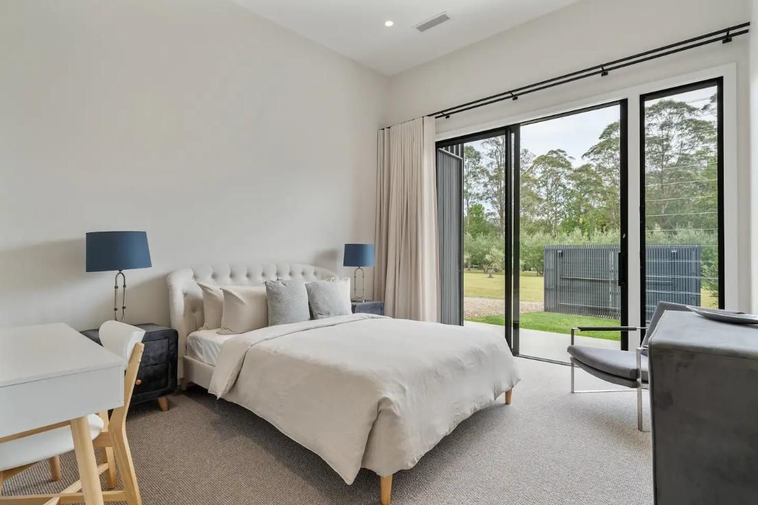 A Bedroom With A Large Bed , Desk , Chair and Sliding Glass Doors — That Painter Guy In South Nowra, NSW