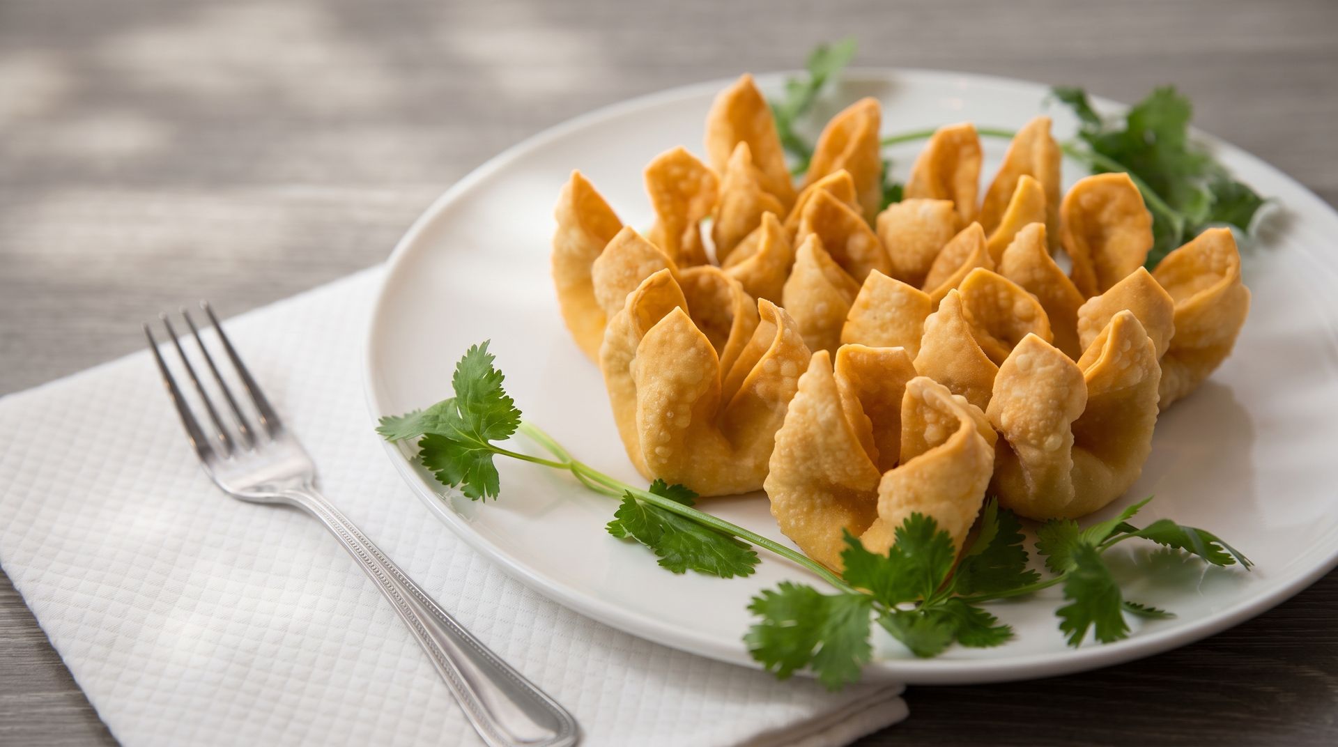 Golden fried pastry cups on a white plate with parsley, beside a fork on a napkin