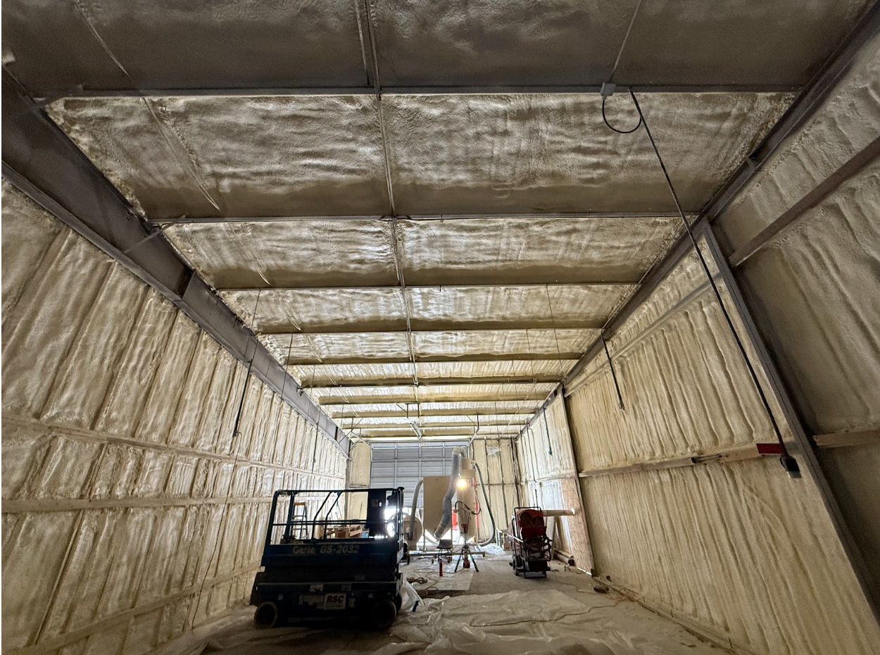 Interior view of a building with spray foam insulation on the walls and ceili