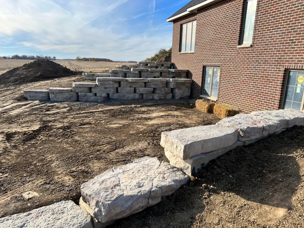 A brick house with a stone wall in front of it.