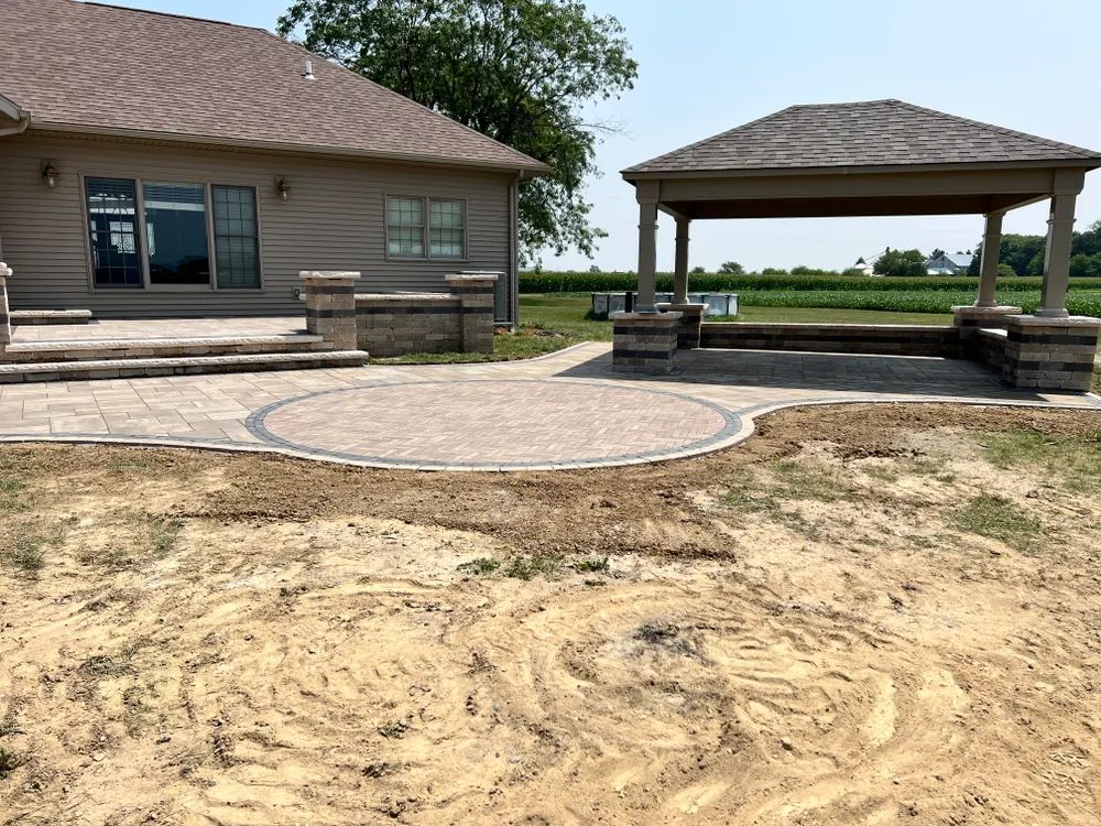 A house with a gazebo and a patio in front of it.