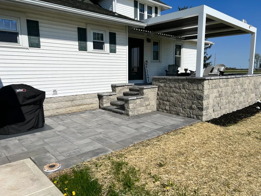A white house with a patio and stairs in front of it.