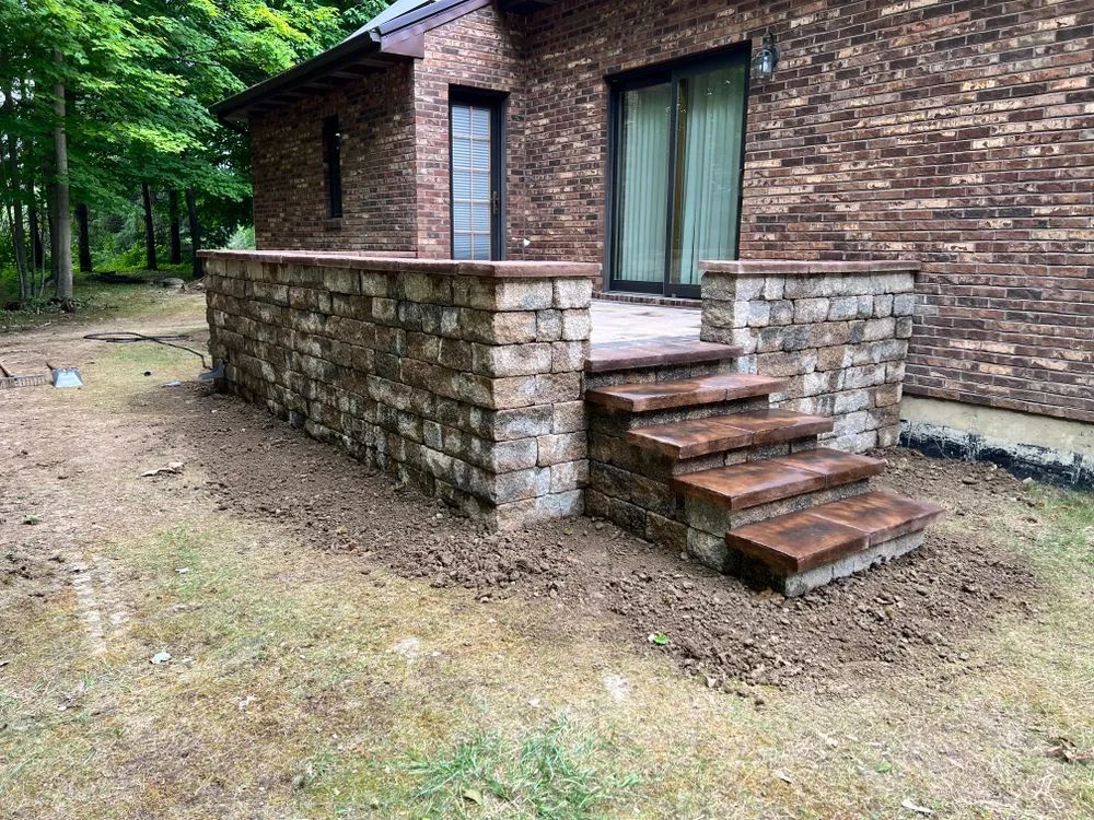 A brick wall with stairs leading up to a brick house.