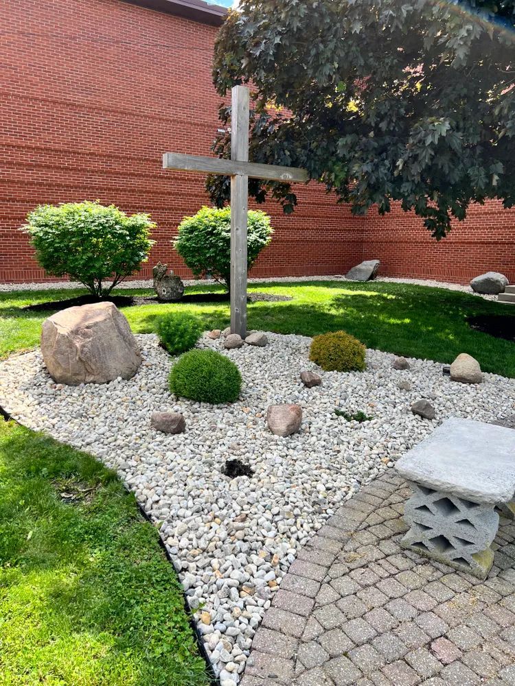 There is a cross in the middle of a rock garden.