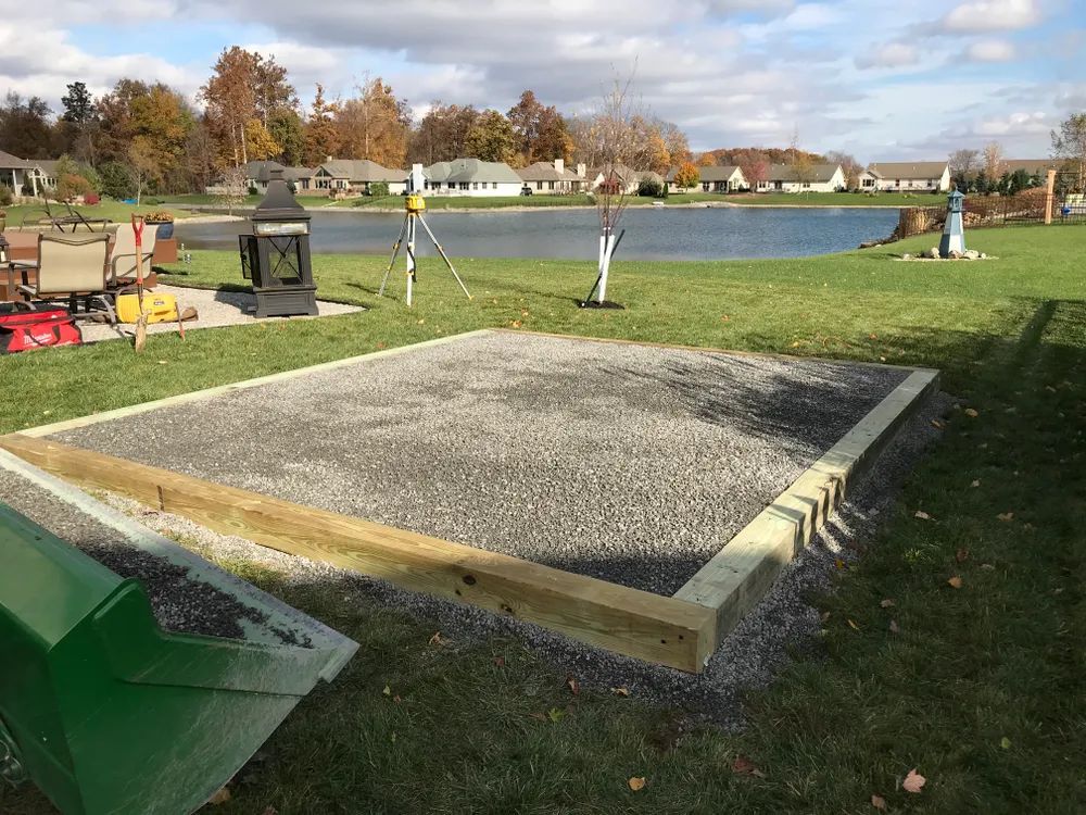A wooden frame is being built in a backyard next to a lake.