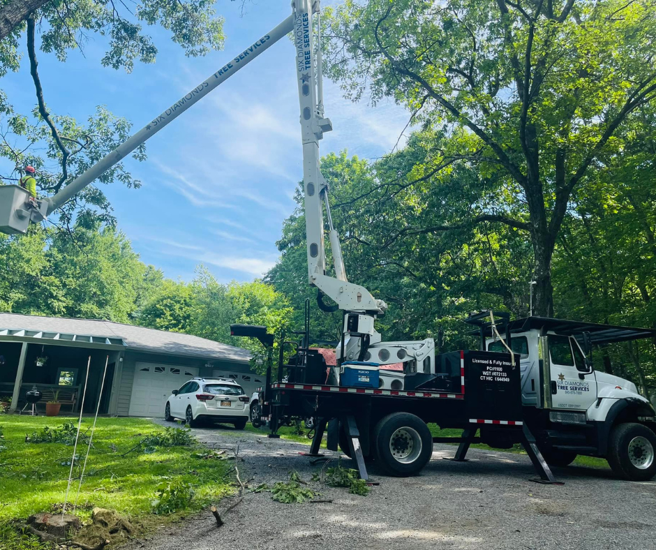 a truck with a crane on top of it is parked in front of a house .