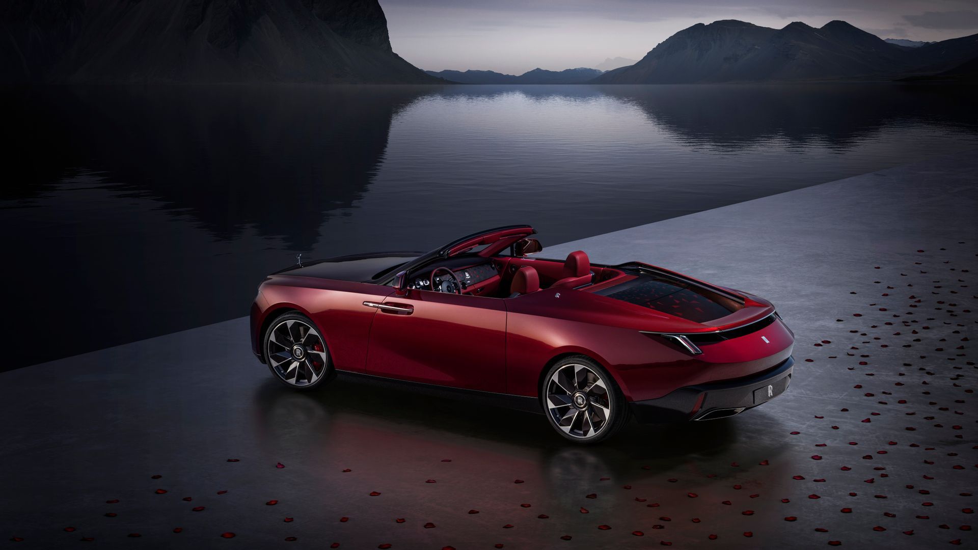 A Red Car Is Parked In Front Of A Lake