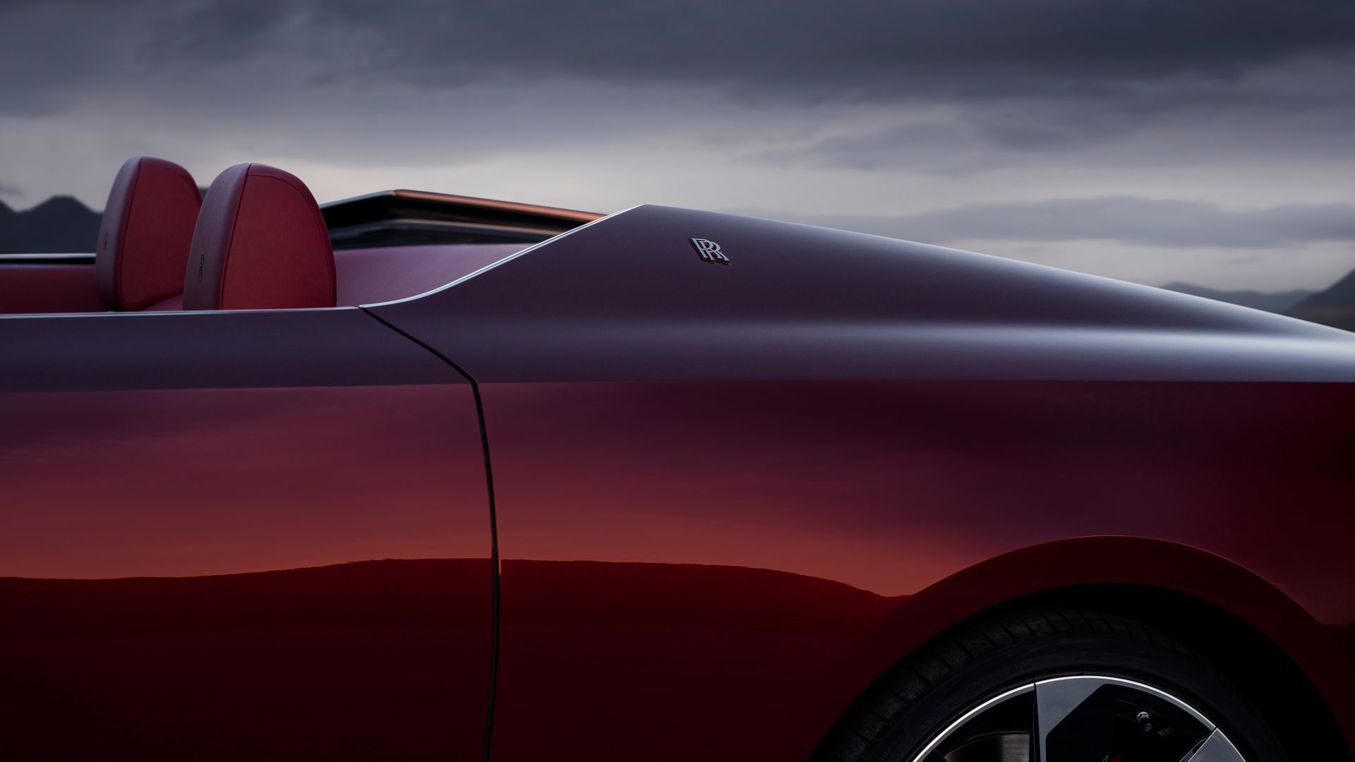 A Red Car Is Parked In Front Of A Lake