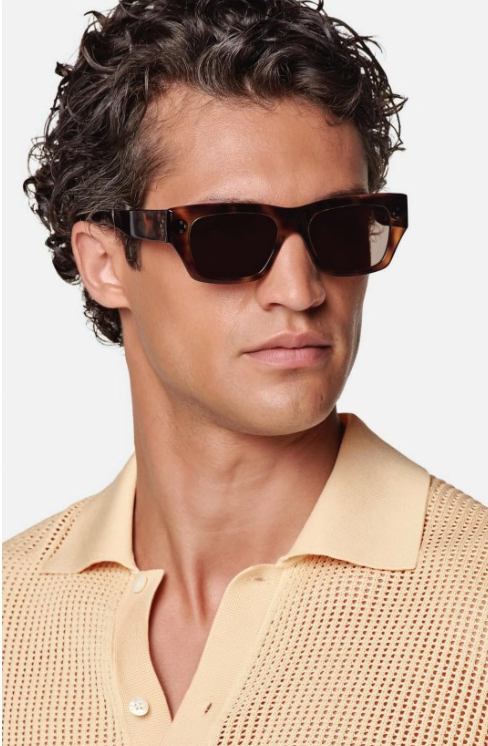A man wearing sunglasses and a yellow shirt