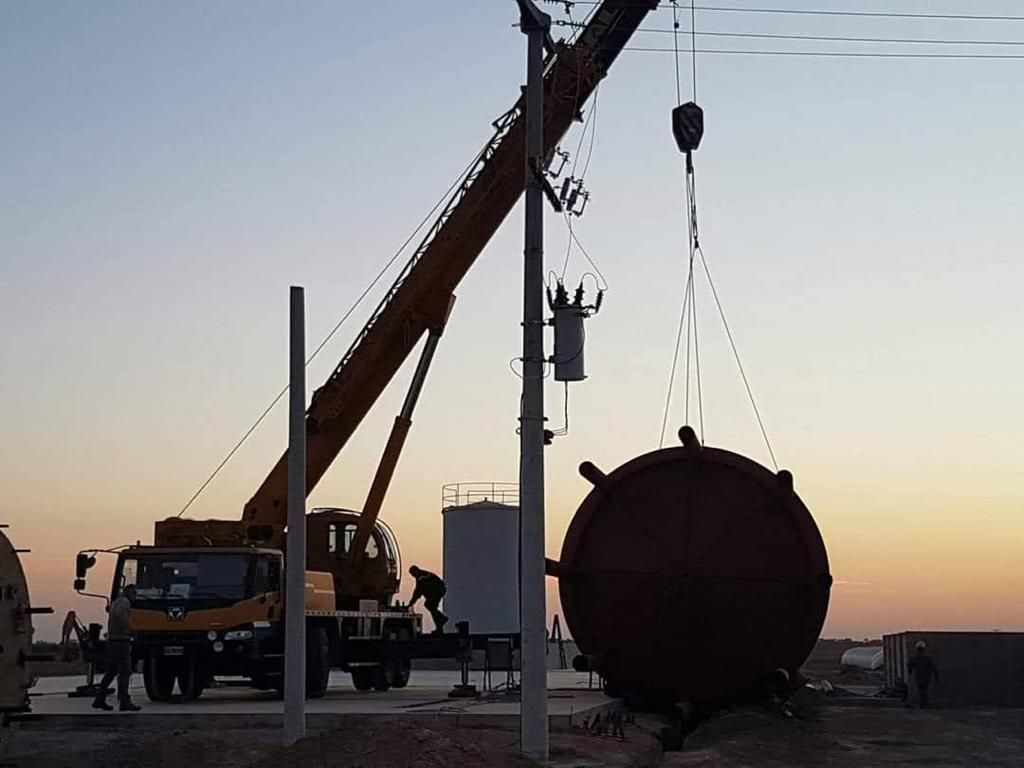 Una grúa está levantando un objeto grande en el aire.