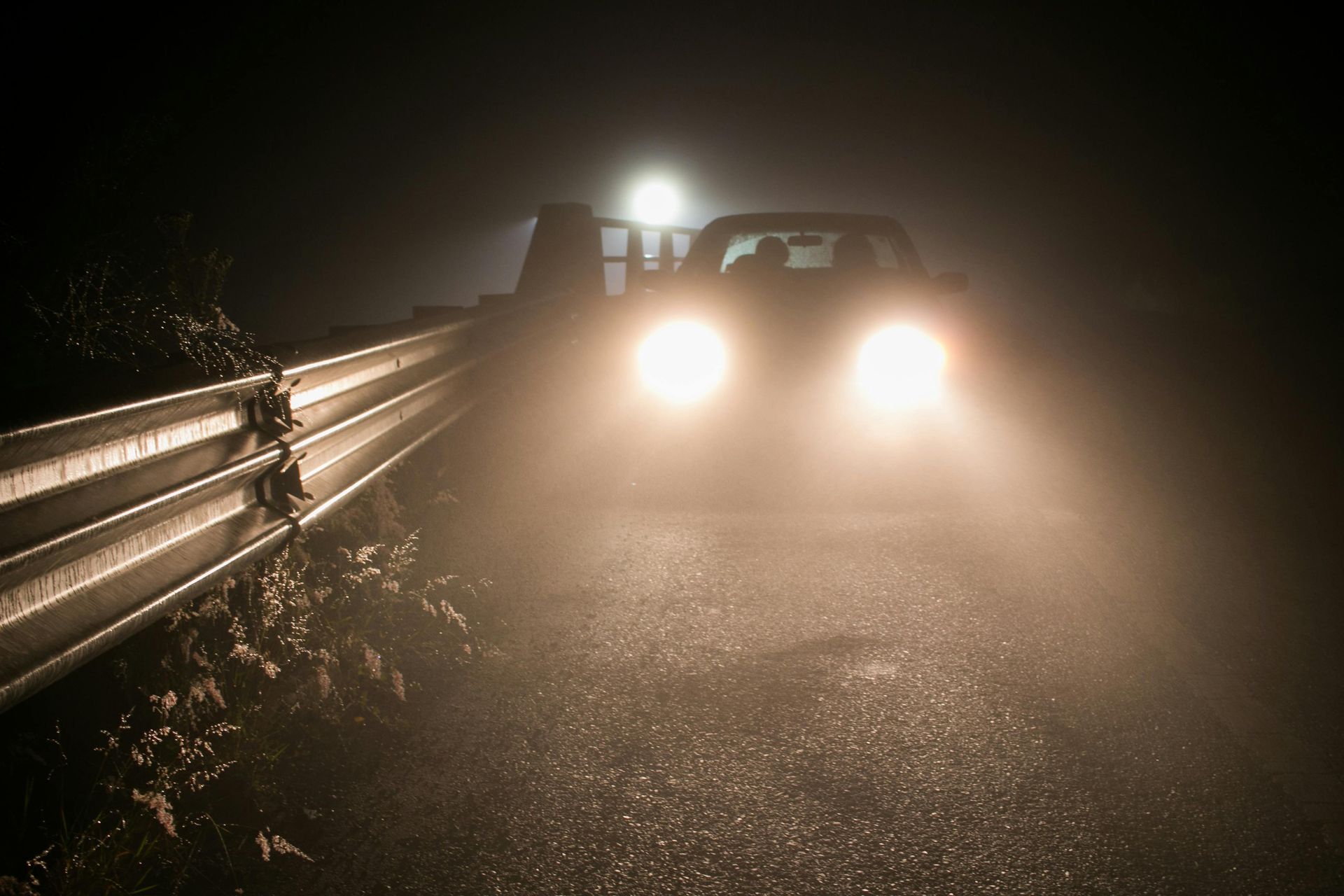 car driving with high beam headlights 