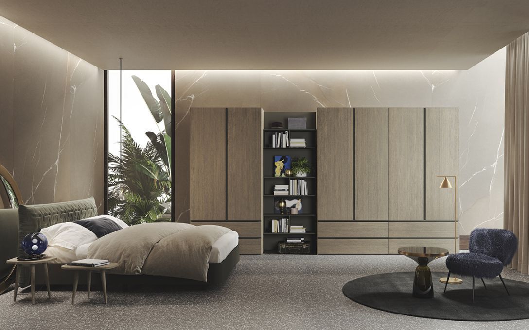 Una camera da letto moderna e minimalista presenta mobili in legno chiaro con ripiani a vista, un letto soffice e una poltrona blu di design.