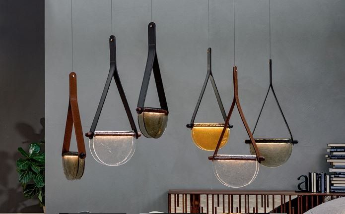Sei lampade a sospensione decorative con cinturini effetto pelle e paralumi a forma di ciotola, appese a una parete grigia.